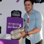 Kris Allen donates a pair of shoes for Soles4Souls at the Barefoot Wine & Bubbly sponsored chairty concert